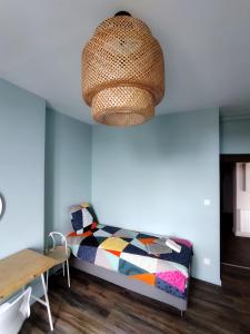 a room with a bed and a chandelier at VOLVIC HOME in Volvic