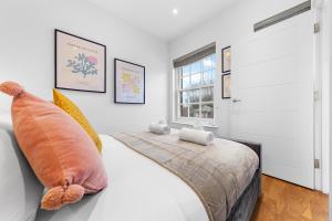um quarto com uma cama com almofadas e uma janela em Modern One Bedroom Flat - Near Heathrow, Windsor Castle, Thorpe Park - Staines London TW18 em Londres