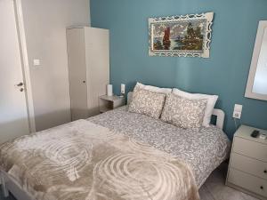 1 dormitorio con cama y pared azul en Jimmis old kalampaka house, en Kalambaka
