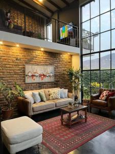 - un salon avec un canapé et un mur en briques dans l'établissement Casa Jardín Del Valle, à Lima