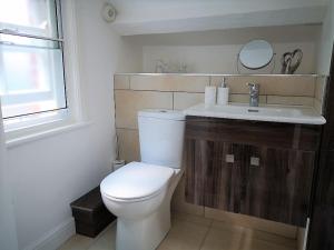 uma casa de banho com um WC branco e um lavatório. em Welcoming luxury in a Grade II listed building em Chester
