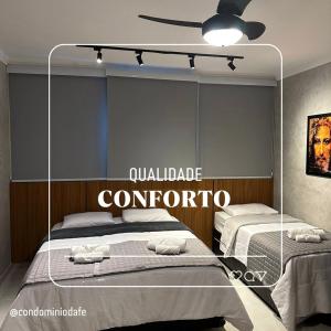 een slaapkamer met 2 bedden en een plafondventilator bij Flat Canção Nova in Cachoeira Paulista