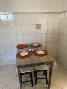 einen Tisch in einem Raum mit drei Platten drauf in der Unterkunft Bela vista a beira mar in Marataizes