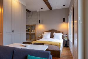 a bedroom with a bed and a table and a couch at Aparthotel Largo da Oliveira in Guimarães
