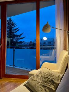 ein Wohnzimmer mit einem Fenster mit Blick auf einen Balkon in der Unterkunft Apartmán Astra in Sezimovo Ústí