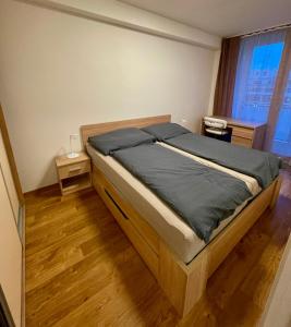 ein Schlafzimmer mit einem Bett in einem Zimmer mit Holzböden in der Unterkunft Apartmán Astra in Sezimovo Ústí