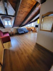 sala de estar con sofá azul y suelo de madera en Mansarda Élite Villaggio Ploner, en Dobbiaco