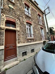 Maison Meulière avec jardin في إيبيرني: سيارة متوقفة أمام مبنى له باب احمر