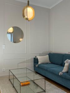 a living room with a blue couch and a glass table at Central, peaceful, high-end apartment in Helsinki