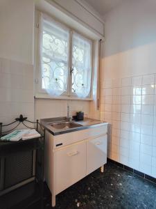 eine kleine Küche mit einem Waschbecken und einem Fenster in der Unterkunft Residenza Il Gabbiano 2 - panoramic rooms in Cannobio