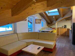 a living room with a couch and a table at Attico Penia Chalet Orchidea in Penia