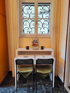 einem Tisch mit zwei Stühlen vor einem Fenster in der Unterkunft Residenza Il Gabbiano 2 - panoramic rooms in Cannobio