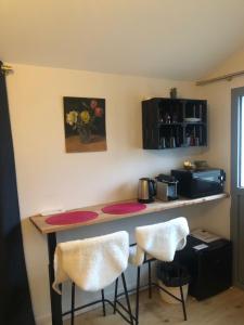 a kitchen with a counter and two stools at Chambre indépendante Charbonnières Les Bains in Charbonnières-les-Bains