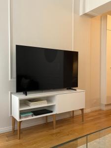 a white entertainment center with a flat screen tv on it at High-end, quiet, downtown home in Helsinki