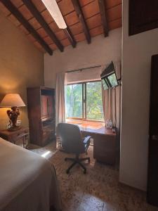 a bedroom with a desk with a chair and a window at 15 - 139 D Beautiful Dept in Los Tules in Puerto Vallarta