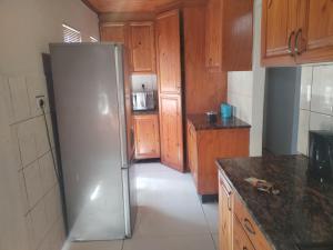 a kitchen with a stainless steel refrigerator and wooden cabinets at 101 Newlands West in Durban