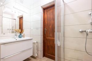 a bathroom with a shower and a wooden door at Pokoje u Kamińskich 26E in Zakopane