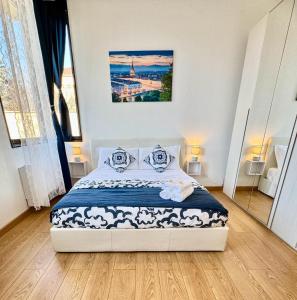 a white bedroom with a bed with a picture on the wall at Nice Turin 26 - Porta Nuova - Metro Marconi in Turin