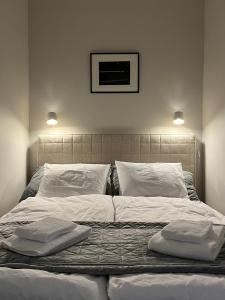 1 cama grande con sábanas blancas y almohadas. en Central, peaceful, high-end apartment, en Helsinki