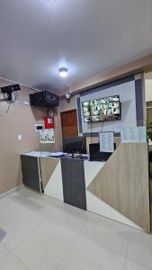 a lobby with a counter with a tv on the wall at HOTEL NILA in Cajamarca