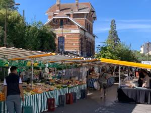 a market with fruits and vegetables in front of a building at La Résidence Alpha Viroflay 002 - 1 chambre - 4 pers in Viroflay