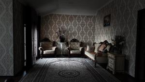 een woonkamer met 2 stoelen en een bank bij Chaqar in Tasjkent
