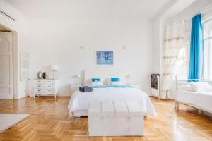 een witte slaapkamer met een bed en een stoel bij Amazing View Designer Home w/Sauna 3min to Opera in Boedapest
