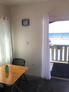 a dining room with a table and a view of the beach at Bri's On The Beach in Treasure Beach