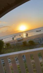 einen Blick auf den Strand bei Sonnenuntergang vom Balkon aus in der Unterkunft Bri's On The Beach in Treasure Beach