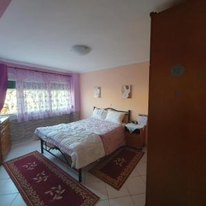 a bedroom with a bed and two rugs in it at Xrisa's house in Kavala