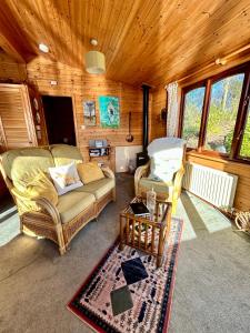 a living room with two couches and a table at 'Little Grebe' - Secluded Rustic Lodge - Fishermans delight. in York