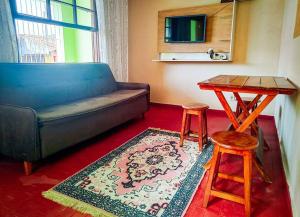 uma sala de estar com um sofá, uma mesa e um banco em Casa 54 em São Sebastião