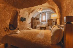 Un dormitorio con una cama grande en una habitación de piedra. en Zula Cave House, en Ürgüp