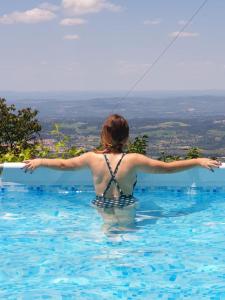 a woman in a swimming pool flying a kite at Casas Da Ribeira in Seia