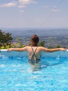 Una donna in una piscina che fa volare un aquilone di Casas Da Ribeira a Seia