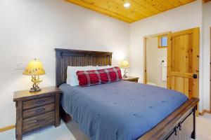 een slaapkamer met een bed met een houten hoofdeinde en 2 lampen bij The Great Outdoors in Pinetop-Lakeside