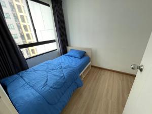 - une petite chambre avec un lit bleu et une fenêtre dans l'établissement 2BR Apartment, à Bangkok