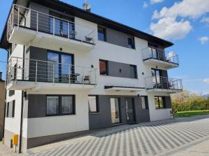 ein weißes Gebäude mit Balkonen an der Seite in der Unterkunft Apartamenty Wakacyjne Historie in Mittelwalde