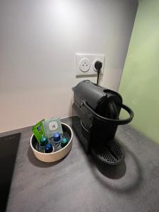 eine Kaffeemaschine und eine Schüssel mit Getränken auf dem Zimmer in der Unterkunft La Résidence Alpha Viroflay 002 - 1 chambre - 4 pers in Viroflay