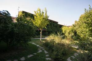un giardino con sentiero in pietra di fronte a un edificio di Locanda dei Melograni a Gossolengo