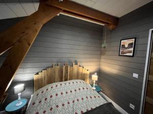 Habitación con cama y pared de madera. en LE CHALET, en Gavarnie