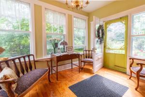 a living room with a table and chairs and windows at The Dawson House Bed & Breakfast in Charlottetown