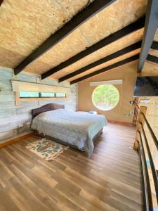 ein Schlafzimmer mit einem Bett und einem großen Fenster in der Unterkunft Cabaña El Polux, ruta x-671 in Coihaique