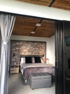 a bedroom with a bed and a stone wall at Verdes Hábitat Glamping in Palestina