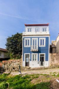 ein blaues und weißes Haus auf einer Steinmauer in der Unterkunft Sao Victor Suites in Porto