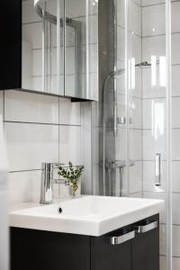 biała łazienka z umywalką i prysznicem w obiekcie Vetteberget Anexet w mieście Fjällbacka