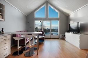 un soggiorno con un tavolo e una grande finestra di Charming Sea-view Haven by AJF Dream Living a Fjällbacka