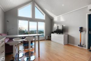 una cucina con tavolo, sedie e televisione di Charming Sea-view Haven by AJF Dream Living a Fjällbacka