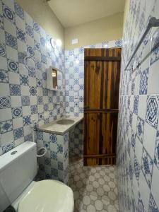 a bathroom with a toilet and a sink at Casa na lagoa azul in Cruz