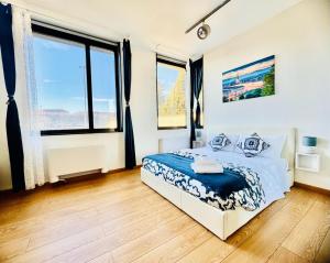 a bedroom with a bed with blue sheets and windows at Nice Turin 26 - Porta Nuova - Metro Marconi in Turin